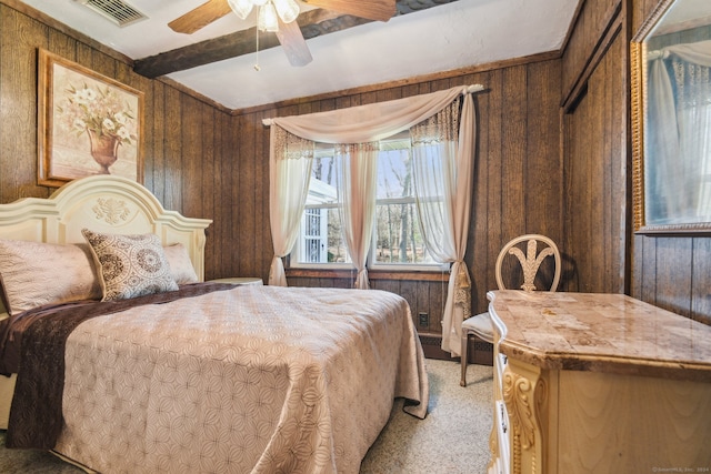 bedroom with carpet, wood walls, beamed ceiling, and ceiling fan