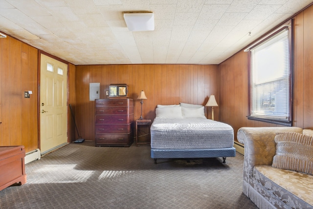 bedroom with dark colored carpet, wood walls, and a baseboard radiator