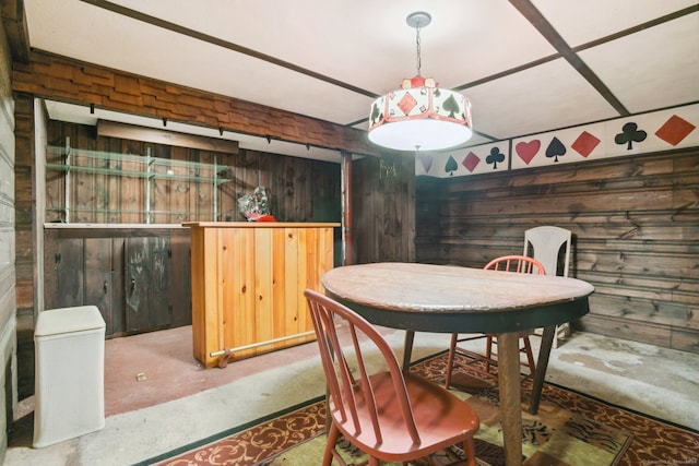 dining room featuring concrete floors and wooden walls