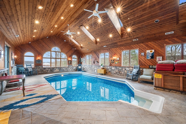 view of pool with a skylight and ceiling fan