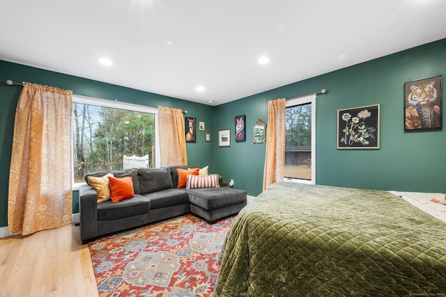 bedroom with hardwood / wood-style floors and multiple windows