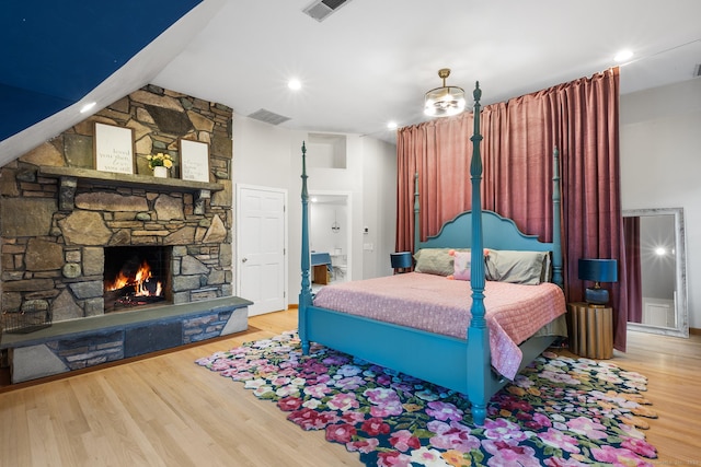 bedroom featuring a fireplace and wood-type flooring