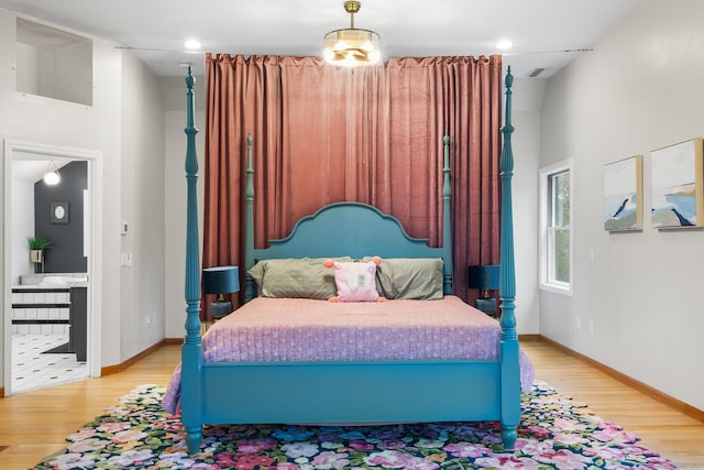 bedroom featuring a notable chandelier and light wood-type flooring