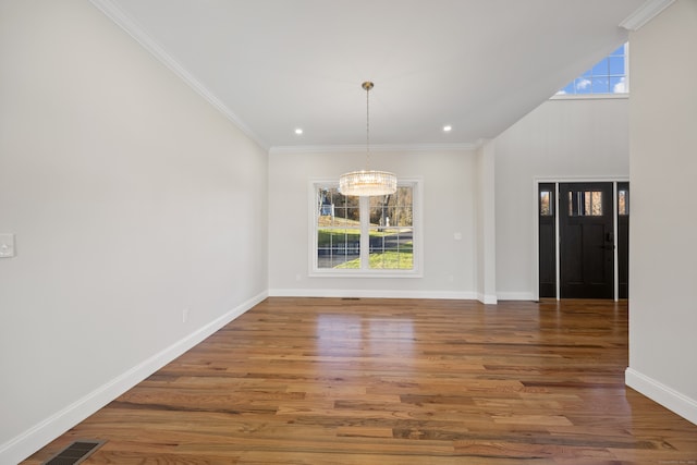 unfurnished dining area featuring a notable chandelier, ornamental molding, and dark wood-type flooring