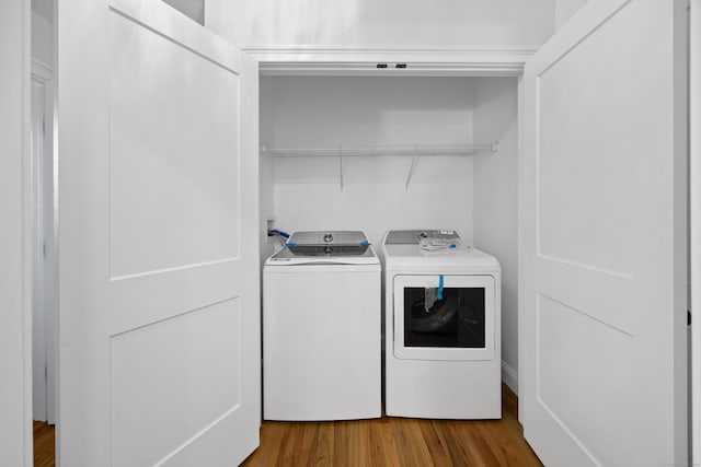 clothes washing area featuring independent washer and dryer and hardwood / wood-style flooring