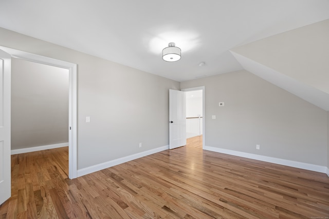 bonus room with light hardwood / wood-style floors and vaulted ceiling