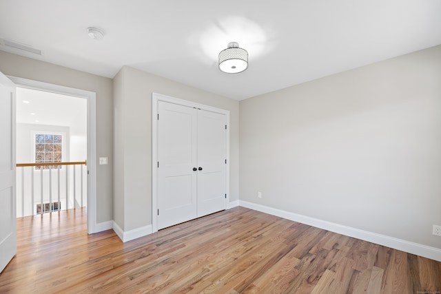 unfurnished bedroom with a closet and light hardwood / wood-style floors