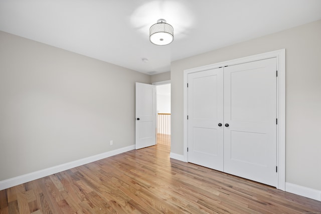 unfurnished bedroom featuring light wood-type flooring and a closet