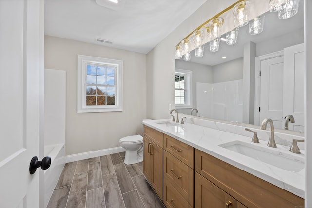 bathroom with vanity, toilet, wood-type flooring, and a wealth of natural light