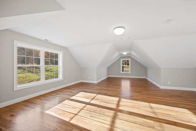 bonus room with vaulted ceiling and light hardwood / wood-style flooring