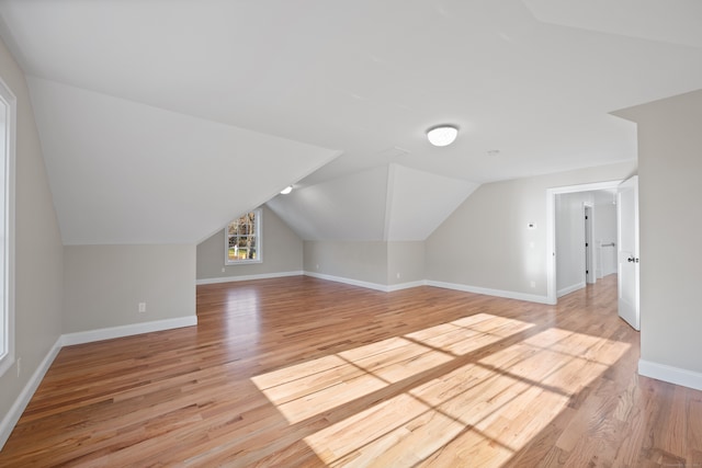 bonus room with light hardwood / wood-style floors and lofted ceiling