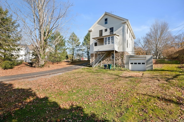 rear view of house featuring a lawn and a garage