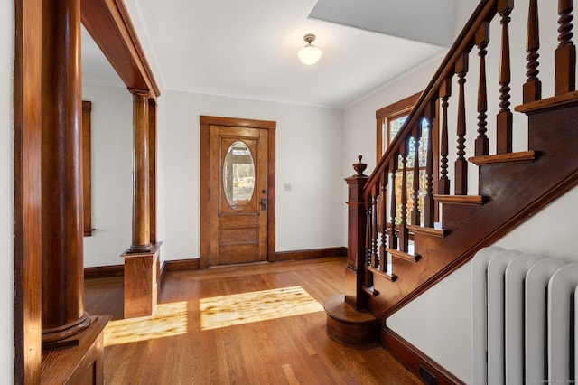 46 Lyme St, Old Lyme, CT 06371 - foyer entrance featuring radiator, decorative columns, crown molding, wood finished floors, and stairway