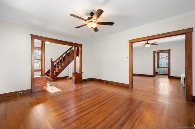 empty room with hardwood / wood-style flooring, radiator, and ornamental molding