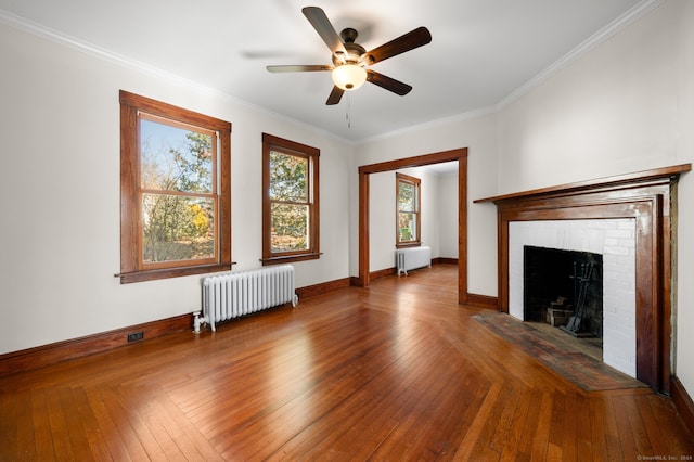 unfurnished living room with crown molding, radiator heating unit, and a brick fireplace