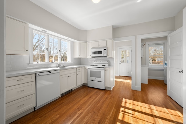 kitchen with white cabinets, white appliances, tasteful backsplash, and light hardwood / wood-style floors