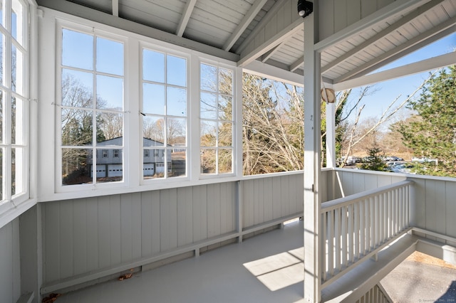 unfurnished sunroom with vaulted ceiling with beams and plenty of natural light