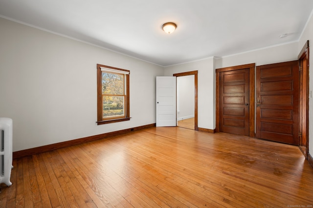 unfurnished bedroom featuring light wood-type flooring and ornamental molding