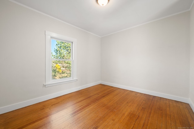 empty room featuring hardwood / wood-style floors and crown molding