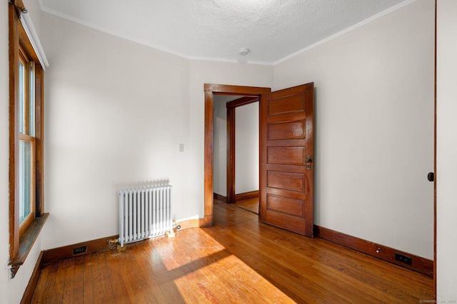 46 Lyme St, Old Lyme, CT 06371 - spare room with radiator heating unit, wood-type flooring, ornamental molding, a textured ceiling, and a smoke detector