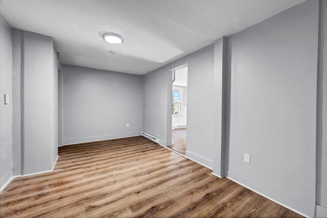 spare room featuring light wood-type flooring and a baseboard heating unit