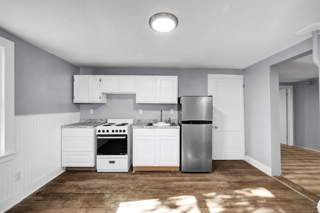 kitchen featuring stainless steel fridge, white range oven, dark wood-type flooring, sink, and white cabinetry