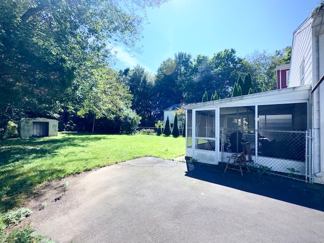 view of patio with a storage unit and a sunroom