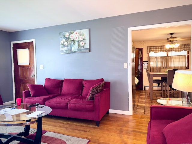 living room featuring wood-type flooring and ceiling fan