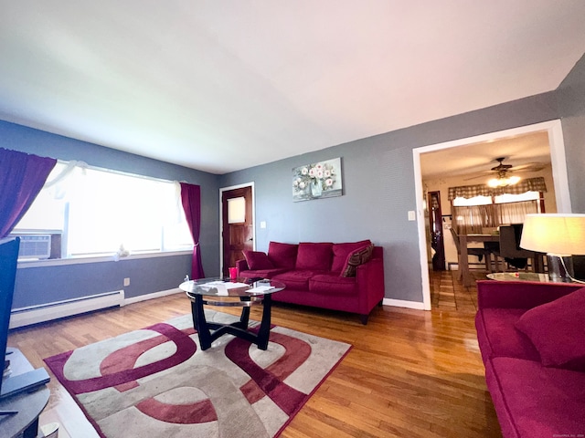 living room featuring wood-type flooring, baseboard heating, cooling unit, and ceiling fan