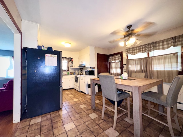 tiled dining space featuring ceiling fan