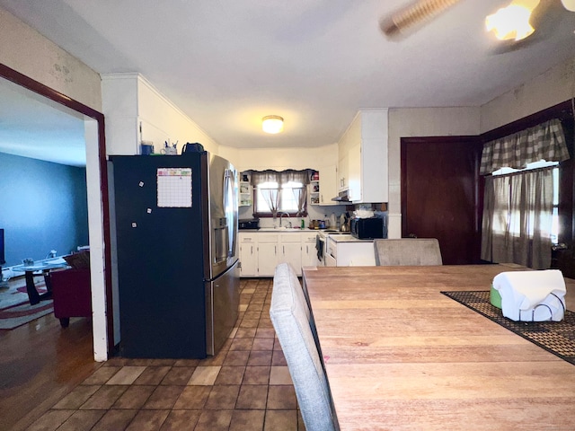 kitchen featuring white cabinetry, sink, dark wood-type flooring, stainless steel fridge, and exhaust hood