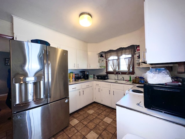 kitchen with white cabinets, dark tile patterned flooring, sink, stainless steel refrigerator with ice dispenser, and white electric range oven