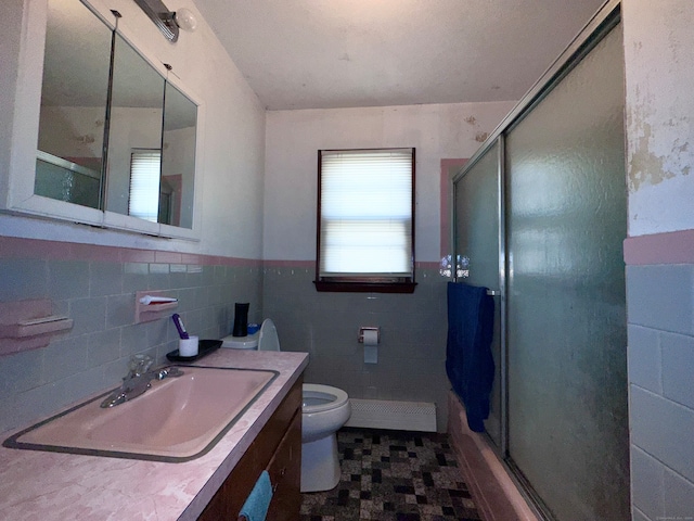 bathroom featuring vanity, tile walls, and toilet