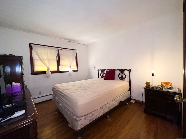 bedroom featuring dark hardwood / wood-style flooring and a baseboard heating unit