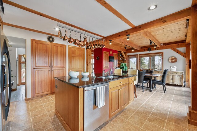 kitchen with sink, wooden ceiling, beamed ceiling, a center island with sink, and appliances with stainless steel finishes