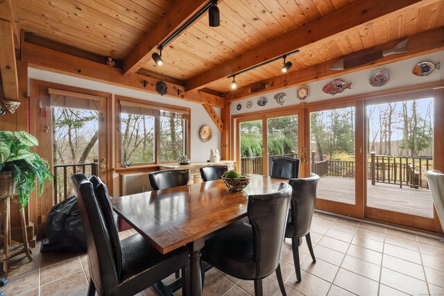 tiled dining area featuring french doors, rail lighting, plenty of natural light, beam ceiling, and wood ceiling