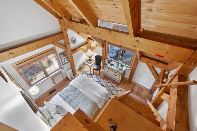 interior space with beam ceiling, radiator heating unit, wood ceiling, and wood-type flooring