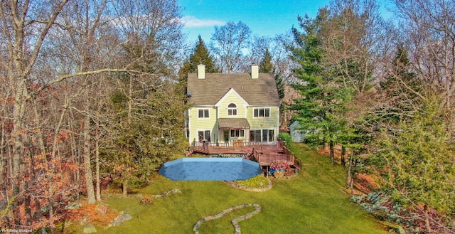 back of house featuring a wooden deck and a yard