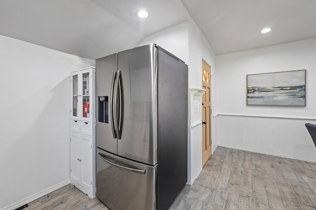 kitchen featuring lofted ceiling, light wood-type flooring, and stainless steel refrigerator with ice dispenser