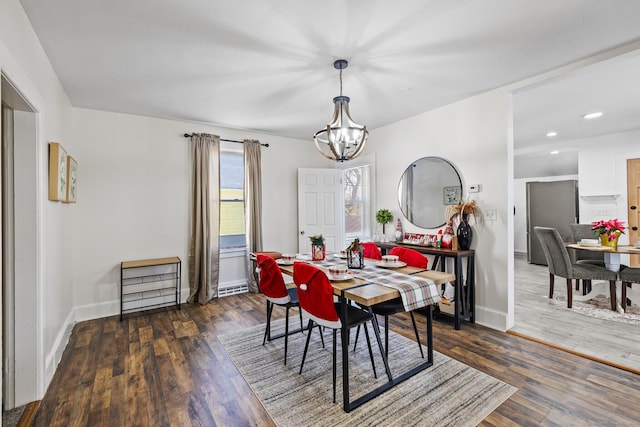 dining room featuring dark hardwood / wood-style flooring and an inviting chandelier