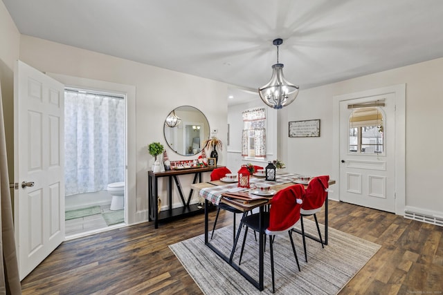 dining area with dark hardwood / wood-style floors and a notable chandelier