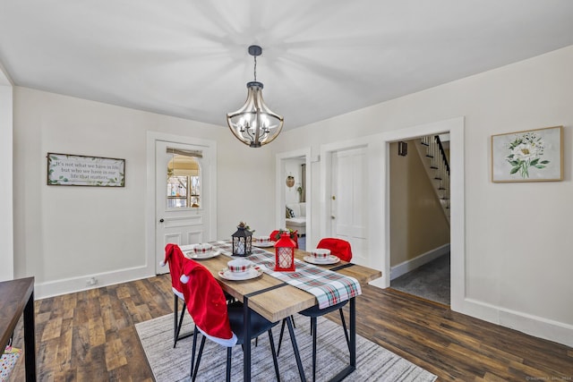 dining area featuring dark hardwood / wood-style floors and an inviting chandelier