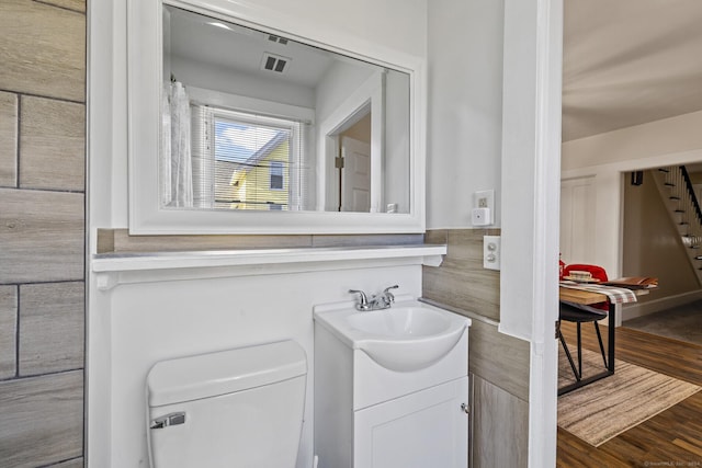 bathroom with hardwood / wood-style floors, vanity, and toilet