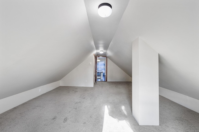 additional living space featuring light carpet and vaulted ceiling