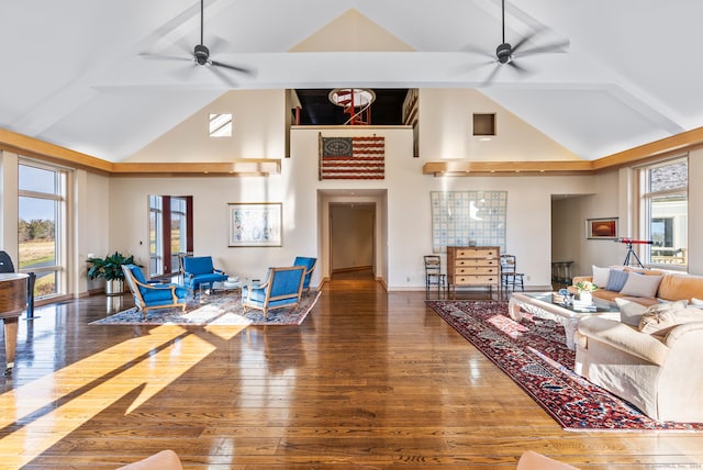 living room featuring ceiling fan, dark hardwood / wood-style flooring, high vaulted ceiling, and a healthy amount of sunlight