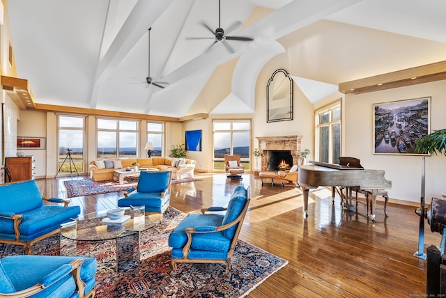 living room featuring beamed ceiling, hardwood / wood-style floors, high vaulted ceiling, and ceiling fan