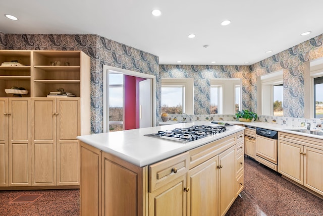 kitchen with sink, light brown cabinets, paneled dishwasher, and stainless steel gas stovetop