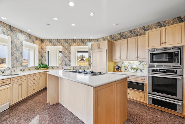 kitchen with a wealth of natural light, a center island, stainless steel appliances, and sink