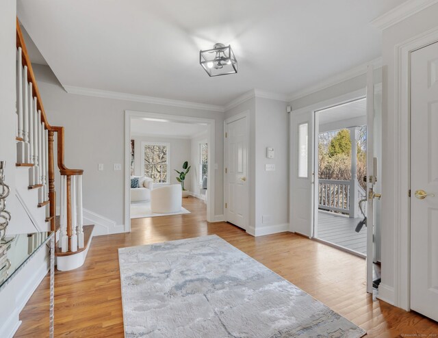 foyer featuring light hardwood / wood-style floors and crown molding