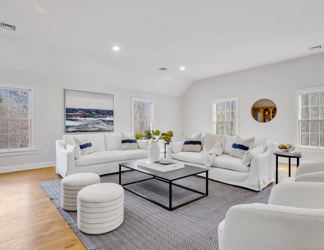 living room featuring light wood-type flooring and vaulted ceiling